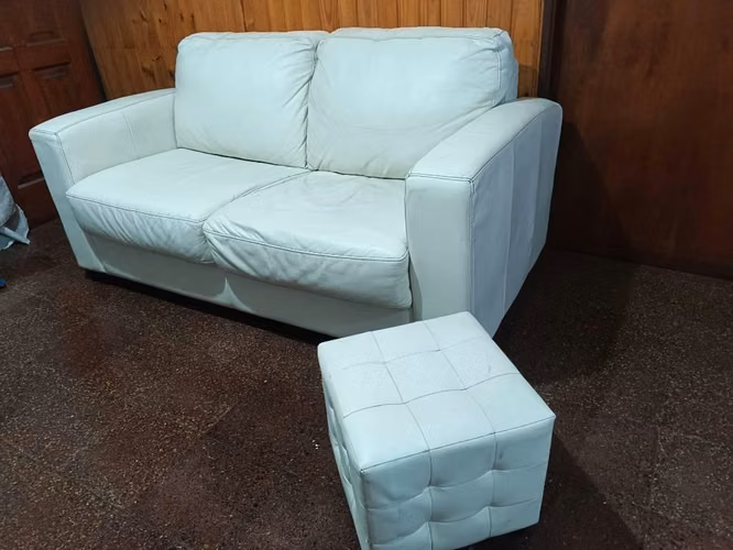 <p>Mueble dos puestos de cuero con puff</p>